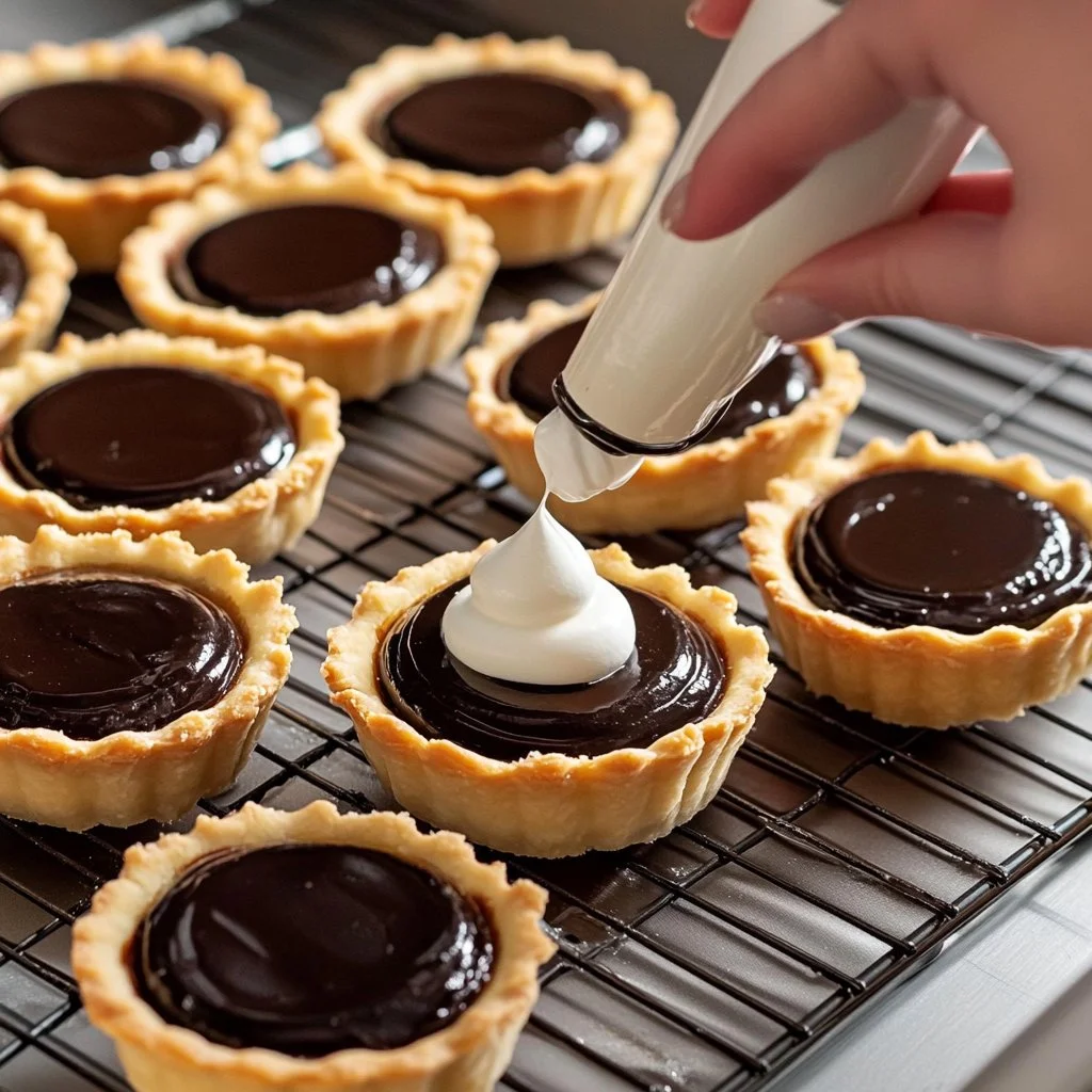 Mini tartas de chocolate recién horneadas decoradas con crema y frutas