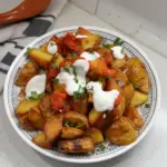Plato de Patatas Bravas servido con salsa picante y alioli