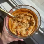 Tazón colorido de panqueques de proteína con frutas frescas y sirope.