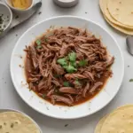 Barbacoa mexicana cocinada en olla de cocción lenta, lista para servir.