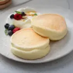 Pancake esponjoso y dorado en un plato, ideal para desayunos sabrosos.