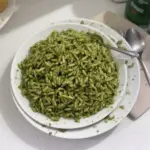 Plato de Arroz Verde Delicioso presentado con perejil y limones frescos.