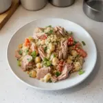 Ensalada de quinoa con atún, ingredientes frescos y saludables en un plato colorido