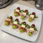 Pinchos de queso y uvas listos para servir en una tabla de aperitivos.